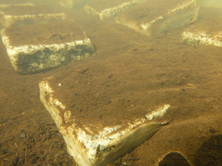 A stone covered in sediment in an experimental channel. Image: Aarhus University
